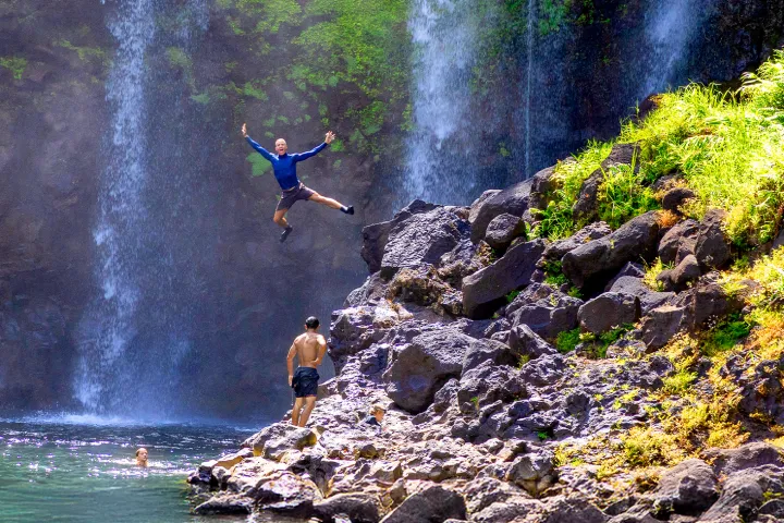 a man standing next to a waterfall