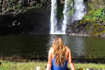 a person sitting next to a waterfall